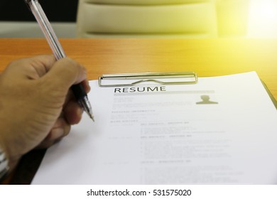 Businessman Or Job Seeker Review His Resume On His Desk Before Send To Finding A New Job With Pen.