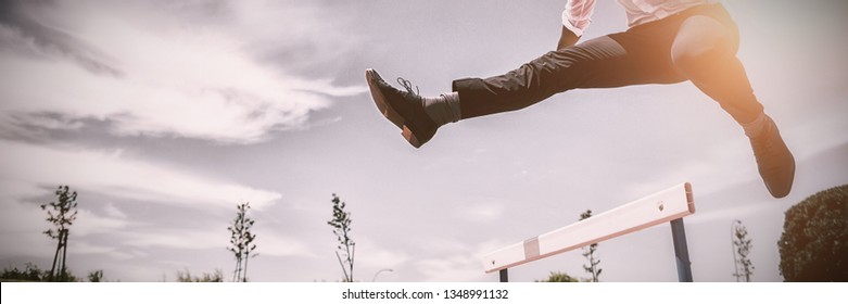 Businessman jumping a hurdle while running on the racing track - Shutterstock ID 1348991132