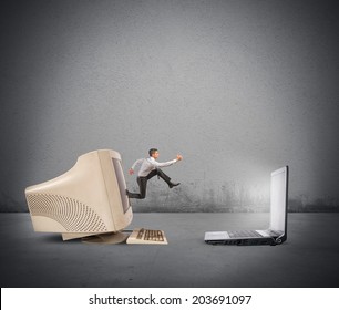 Businessman Jumping From Old Computer To New Laptop