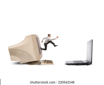 Businessman Jumping From Old Computer To New Laptop