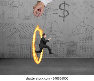 Businessman jumping through fire circle hand holding with doodles wall background