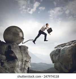 Businessman jumps the obstacle with the weight - Powered by Shutterstock