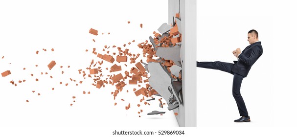 Businessman Kicking Hard The Wall And Crush It, Side View. Overcoming Obstacles. Business Issues. Economic Development.