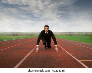 Businessman Kneeling On A Starting Grid