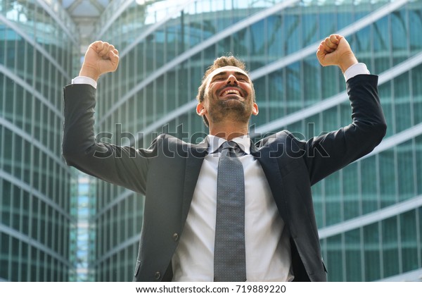 A businessman laughed with open arms and smiling for her success in working in the economic and financial sphere. Concept of: success, exultation, business, freedom.