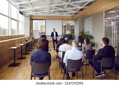 Businessman lead head business training or seminar for diverse businesspeople in boardroom. Male coach or trainer make presentation on whiteboard for office employees or workers. - Shutterstock ID 2147192393