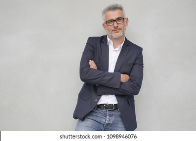 Businessman leaning on concrete wall, isolated