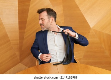 Businessman Leaving Corporate Work Taking Off His Tie With Anger