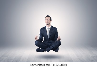 Businessman levitates and sitting in yoga position in an empty infinity space