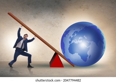 Businessman lifting the earth in challenge concept - Shutterstock ID 2047794482