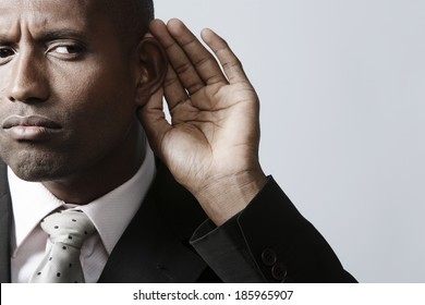 Businessman Listening With Hand On Ear