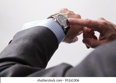 Businessman look his watch, isolated on a grey background - Shutterstock ID 95161306