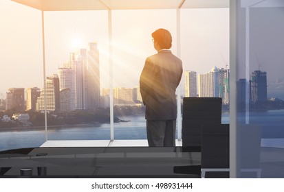 Businessman Looking At City Through Window,thinking Concept / Man Standing At Office And Looking Forward In The Future For Making Ideas  Or Decision Some Things , Use For  Business  Ideas