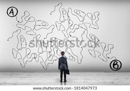Businessman looking at a complicated path of point to point b . 