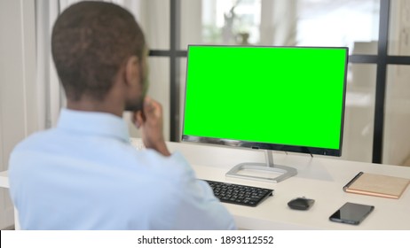 Businessman Looking at Desktop with Green Chroma Key Screen