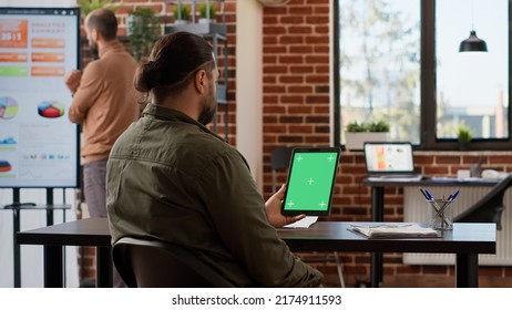 Businessman looking at digital tablet with greenscreen display in company office. Using isolated blank copyspace template with chroma key background and mockup on wireless gadget. - Shutterstock ID 2174911593