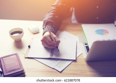 businessman looking at financial data with graphics and charts while work on a laptop computer, young entrepreneur analyzing his notebook, male freelancer work in cafe,selective focus,vintage color - Powered by Shutterstock