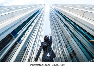 Businessman Looking Up At The High Building, Low Angle