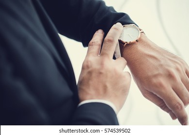 Businessman looking at his watch in office - Powered by Shutterstock