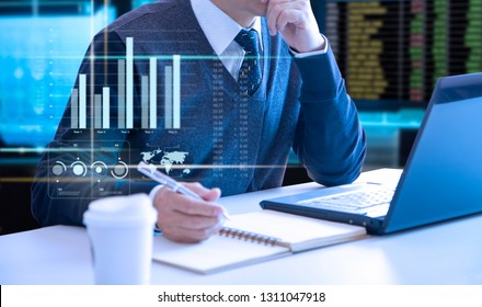 Businessman looking into a laptop notebook computer screen reviewing a return on investment or business performance with colourful graphs. - Shutterstock ID 1311047918