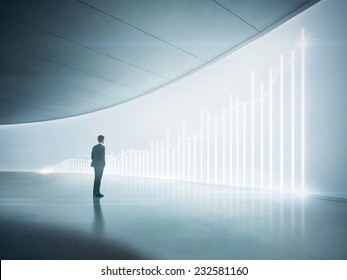 Businessman looking at shining chart on the wall