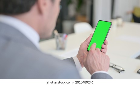 Businessman Looking at Smartphone with Green Chroma Key Screen  - Powered by Shutterstock