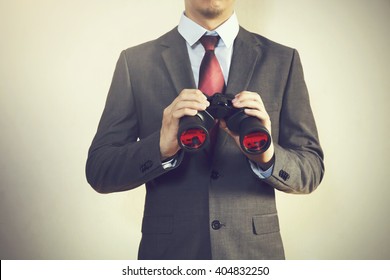 Businessman Looking For Something With Binoculars Such As Business Opportunities / Jobs / New Market - Business Issues Discovery Concept (vintage Tone)