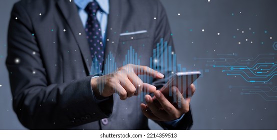 Businessman Looking At A Stock Market Volatility Graph On His Smartphone As A Photo Illustrating A Room With A Picture Of A Forums Icon In His Hand With Orange And White Flares.