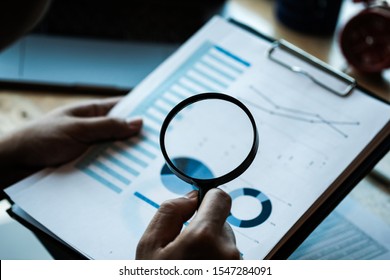 Businessman looking through a magnifying glass to documents. Business assessment and audit. Magnifying glass on a financial report.Concept of search. - Shutterstock ID 1547284091
