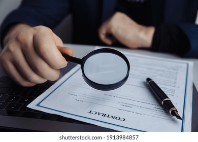 Businessman Looking Through Magnifying Glass To A Contract