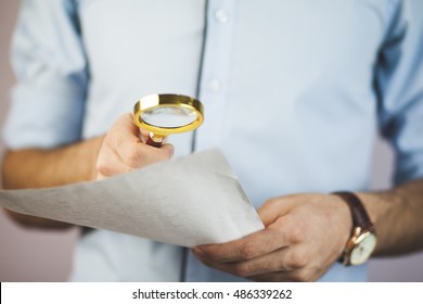 Businessman Looking Through A Magnifying Glass To Contract