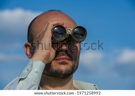 Man observing something through binoculars