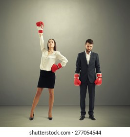 Businessman Loser And Winner Businesswoman In Red Boxing Gloves Over Dark Grey Background