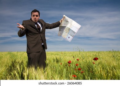 Businessman Lost In Field Using A Map