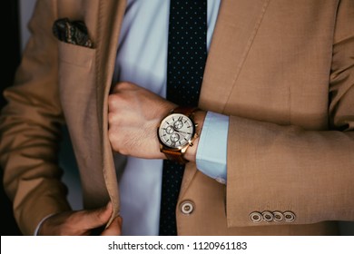 Businessman luxury style. Men style.correct button on jacket, hands close-up, dressing, man's style, stylish man.Fashion portrait of young businessman handsome model man in casual cloth suit. - Powered by Shutterstock