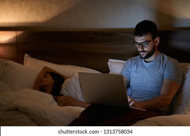 Businessman Lying On Bed At Home And Working With Laptop Late At Night.
