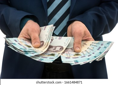 businessman made huge profits, showing a lot of money. a man in a suit holds a pack of new banktons of Ukraine. 1000 hryvnia - Shutterstock ID 1661484871