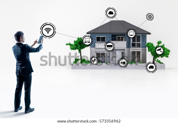 businessman making connection to smart house with\
tablet PC