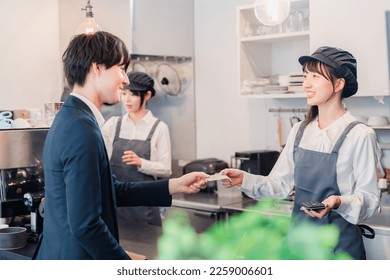 A businessman making a credit card payment at a café - Powered by Shutterstock