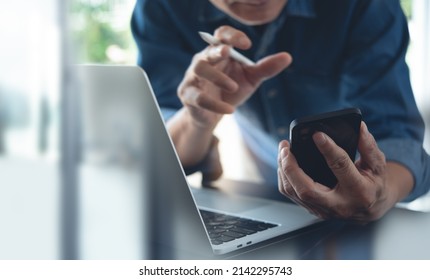 Businessman Making Face Time Video Calling, Using Online Meeting App Via Mobile App On Smart Phone With Laptop Computer And Digital Tablet On Office Table, Working At Home, Telecommuting Concept