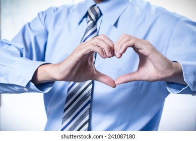 Businessman making a heart with his hands over white background, I love business
