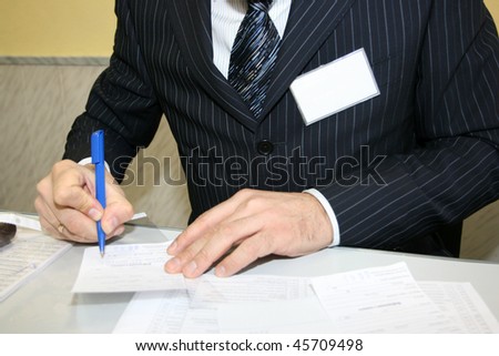 A businessman making notes with a pen