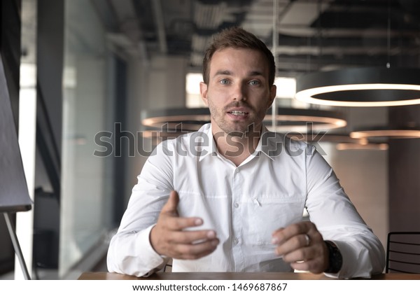 Businessman making video call, looking at\
camera and talking, discussing strategy with partners online,\
millennial business coach mentor recording webinar, hr manager\
holding distance job\
interview