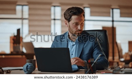 Businessman making work notes on papers at office desk closeup. Handsome bearded manager feeling busy working with financial report. Formal suit man holding pen writing schedule at computer table 