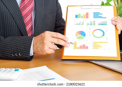 A businessman man explaining using graph materials