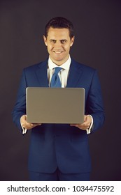 Businessman, Man Or Happy Manager Smiling With Laptop On Grey Background. Formal Blue Suit And Tie. Technology For Business. Fashion And Dress Code. Digital Marketing. Buy Online