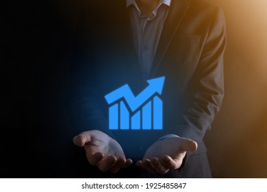 Businessman man holding a graph with positive profits growth. plan graph growth and increase of chart positive indicators in his business.more profitable and growing - Shutterstock ID 1925485847