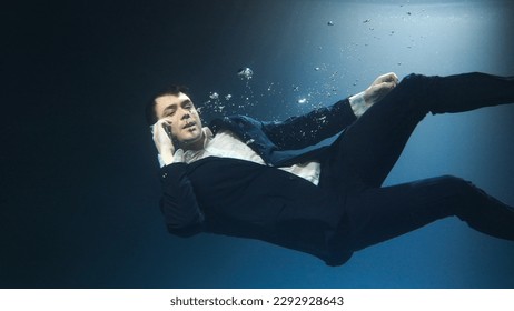 Businessman, a man in a suit, talking on a mobile phone and drowning - Powered by Shutterstock