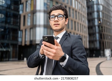 A Businessman Man Uses A Phone In His Hands Writes A Message Reply To A Colleague By Mail.