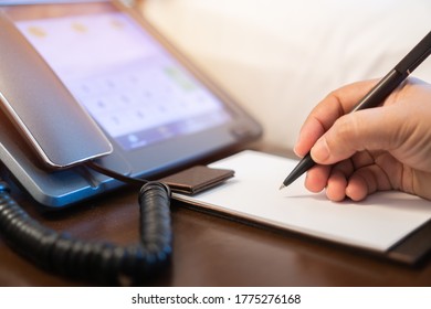 Businessman Manager Signing Document Report Note On Paperwork At Desk Phone Beside The Bed In Hotel, Holding Pen Writing On Paper Documents Working In Call Center In Business